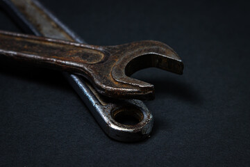Wrench and adjustable wrench on a black background. Old working tools. Steel tools