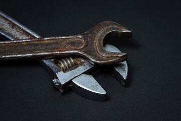 Wrench and adjustable wrench on a black background. Old working tools. Steel tools