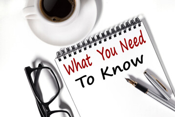 WHAT YOU NEED TO KNOW. text on white notepad paper on white background. near a cup of coffee