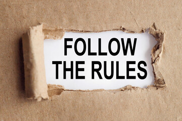 Follow The Rules, text on white paper over torn paper background.