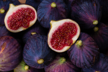 Tasty figs in a bowl on wooden background. Top view.