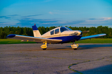 Quadruple aircraft parked at a private airfield. Rear view of a plane with a propeller on a sunset background. - obrazy, fototapety, plakaty