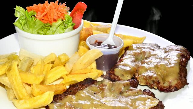 Deliciosa milanesa con queso derretido con vapor, papas fritas y ensalada fresca