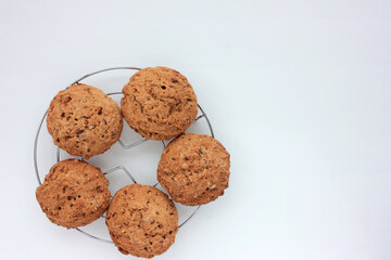 Homemade oatmeal cookies on white table. Overhead view of oat biscuits on white background with copy space, selective focus