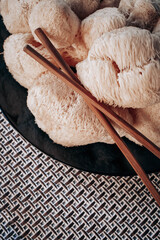 Hericium erinaceus or Lions mane mushrooms on a plate with Chinese sticks. © stivog