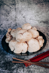 Hericium erinaceus or Lions mane mushrooms on a plate with Chinese sticks. © stivog