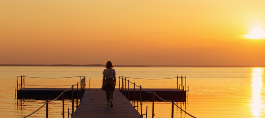 girl on pontoon pier at sunset