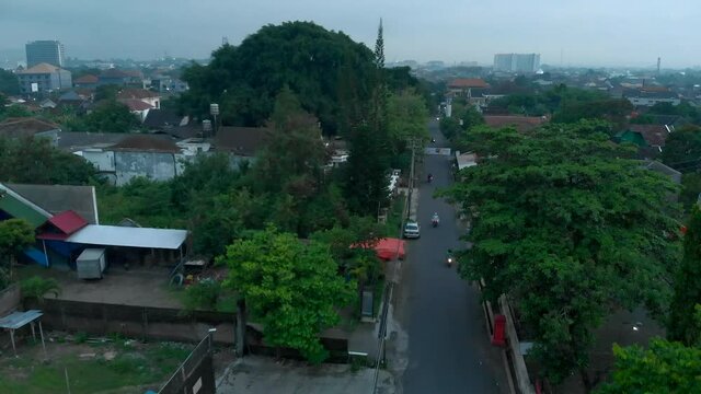 Aerial landscape view of small road, houses and green trees in local neighbourhood of Yogyakarta city, Indonesia during covid19 pandemic