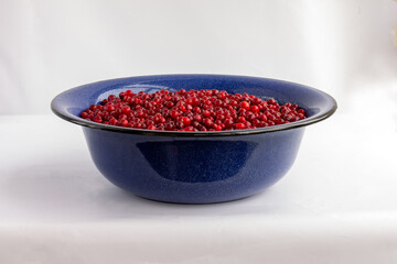 Cooking lingonberry jam. Lingonberries in blue basin