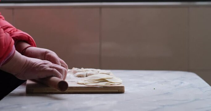 close up hand using rolling pin making dumpling wrapper. Prepare for Chinese dumpling