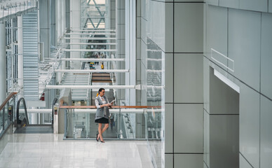 Businesswoman reading paper document in modern office building