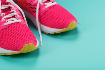 Pink sports sneakers for running on a blue background with free space.