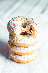 Colorful donuts on bright wooden background