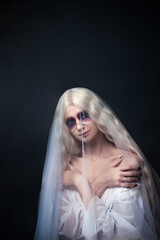 fabulous, magical photo for halloween party portrait of a beautiful woman in the image of a ghost bride on a gray background