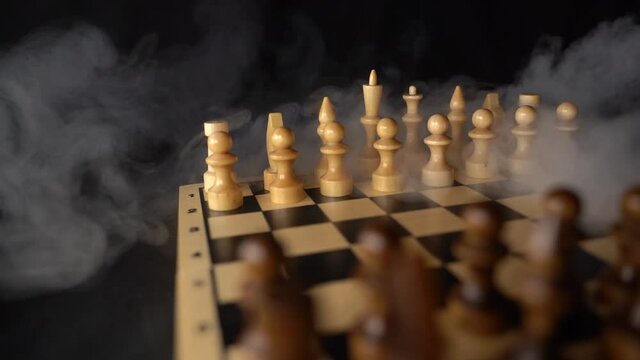 Close up of white and black chess pieces on board. Selective focus on first move of white pawn on chessboard. Concept of intelligent, logical and strategic game.