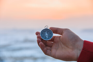 man holding compass in snowy nature