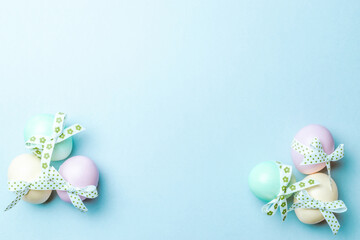 Easter eggs background. Colourful egg with tape ribbon on pastel blue background in Happy Easter decoration. Foil minimalist egg design, modern top view template.