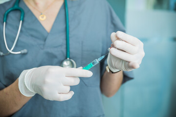 Sanitaria con guantes introduciendo la vacuna en el vial