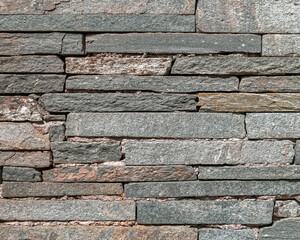 rough grey slate stone wall closeup, textured pattern background