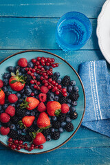 Healthy breakfast eating a mix of fresh berries fruits