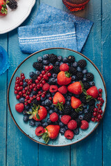 Healthy breakfast eating a mix of fresh berries fruits