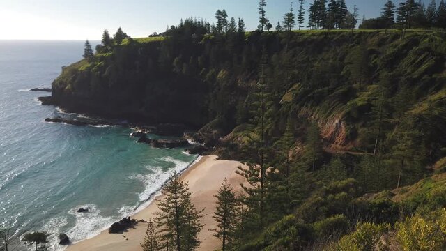 Bottom to top tilt pan motion view of the beach and beautiful scenery of Anson Bay on the west west coast of Norfolk Island, Australia