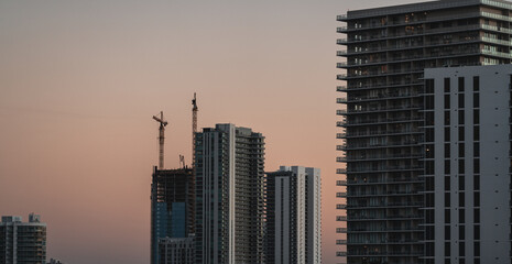 Fototapeta na wymiar skyscrapers at sunset construction cranes population apartments rents miami florida 