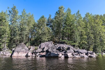 Russia, Lake Ladoga, August 2020. Deciduous forest on the rocks in the middle of the lake.