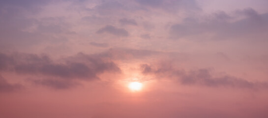 evening sky background with sinking sun and pink clouds