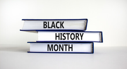 Black history month symbol. Books with words 'Black history month'. Beautiful white table, white background. Black history month concept. Copy space.