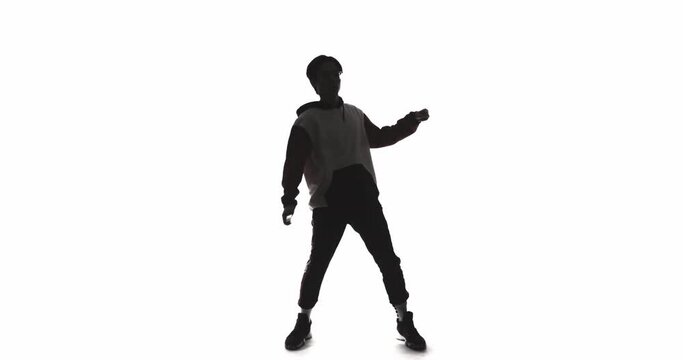 Dancer silhouette. Funky lifestyle. Hip hop culture. Modern choreography. Dark contrast outline of Asian guy performing freestyle movements isolated on white copy space background.