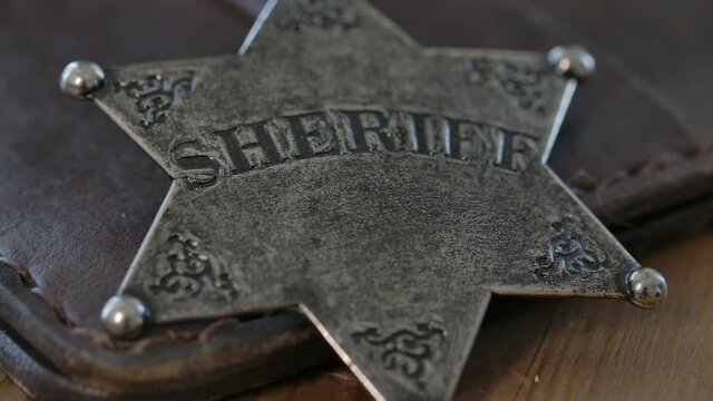Old west Sheriff badge macro close up on a leather wallet - police in the old west of America