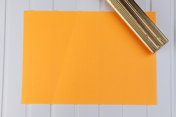 Kartka pomarańczowa na białym blacie - obrazy, fototapety, plakaty