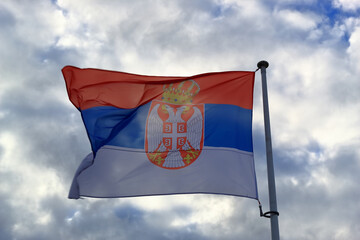 Serbian flag waving on the wind on cloudy sky