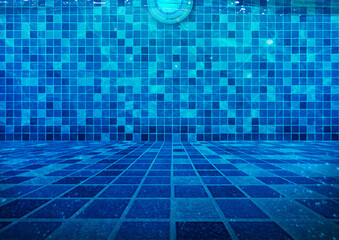 Clear Water at the Bottom of the Swimming Pool with Underwater Lighting Blue Tiles Background