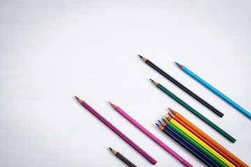 Concept of return to school coloured crayons on a white background with ample free space for text.