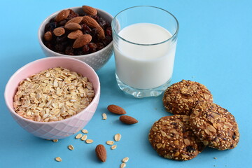 two bowls with raisin and oatmeal and oat cookies on the blue background