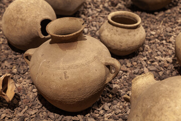 Ancient clay jugs stand on the rocky ground