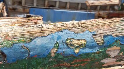 close up of peeling paint on wooden shipwreck in Greece