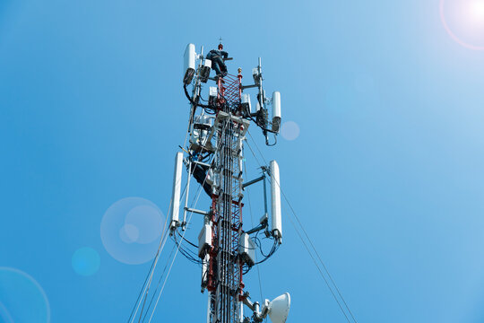 workers are working at 5g antenna tower for maintaining.serves cellular antenna, technician worker repair telecommunication tower on sunlight at background.	
