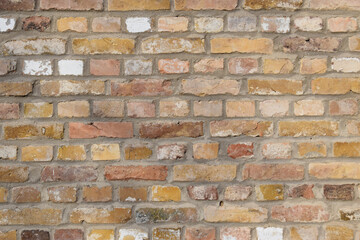 Mauer aus recycelten alten gelb-orangenen Backsteinen