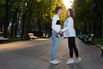 Full size portrait of loving young couple in park holding hands. First date