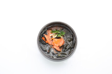 A top view of a fish broth with salmon. A Japanese, clear fish soup.