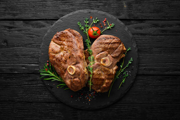 Grilled lamb steak with spices and rosemary. Barbecue meat. Top view. Flat lay top view on black...