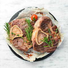 Osso buco cooked Veal shank with spices and vegetables on a white wooden background. Flat lay. Top view.