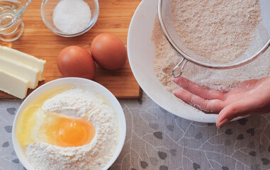 Sifting flour. Ingredients for homemade pancakes. Cooking for someone special concept. Top view