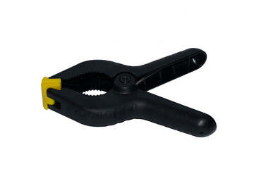 Obraz premium A black spring clamp with yellow rubber tip in a white background for woodworking