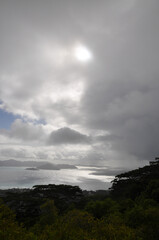 Ocean view over Praslin island with dramatic and overcast sky with sunbeam on the sea