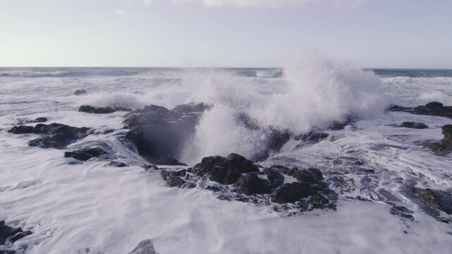 Slow motion of waves crashing large eruption of water Thor's Well Oregon coast