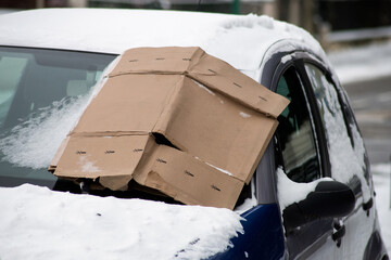 Closeup of carton on the windscreen of carton protection against the snow and freeze